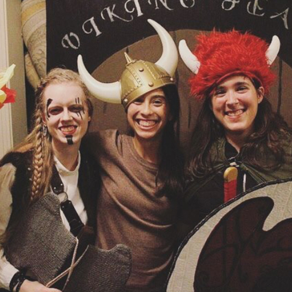 Three students smile as they wear Viking attire at the Honors College Viking Feast.